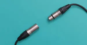 A male and female XLR connector in front of a blue background.
