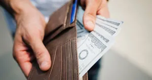 A person pulling money out of their wallet.