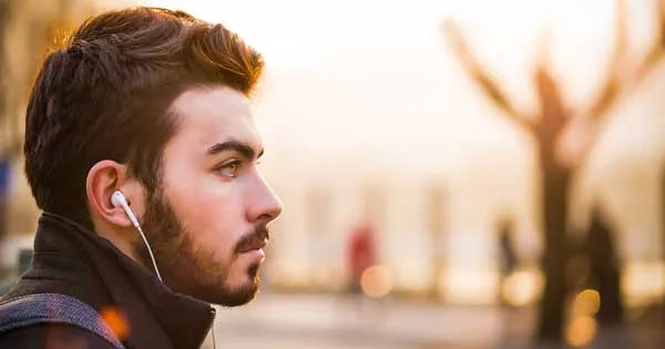A man listening to music using earbuds.
