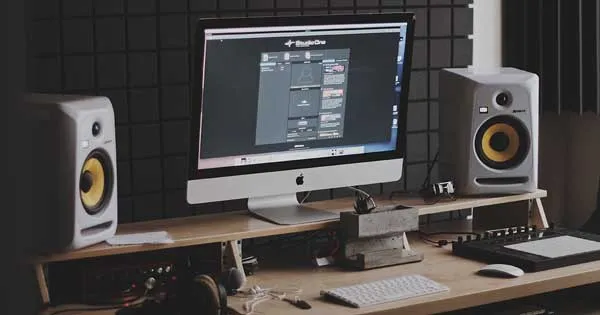 A computer screen and studio monitors placed on a desk.