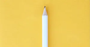 A white pencil with a yellow background.