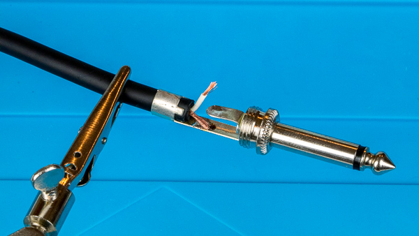 An image of an instrument cable with a 1/4" TS phone plug clamped to the base.