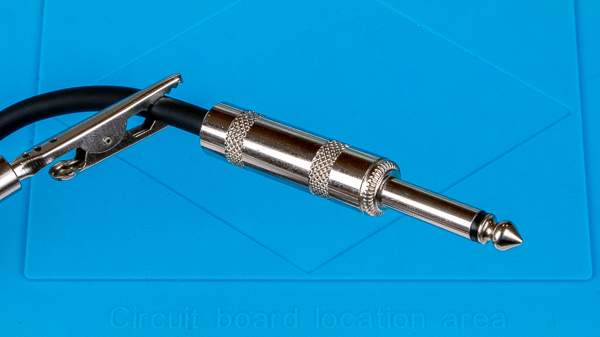 An image of an assembled 1/4" TS phone plug soldered to an instrument cable.