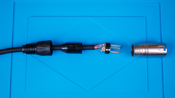 An unassembled XLR connector soldered to a microphone cable.