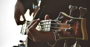 A bassist strumming a bass guitar.