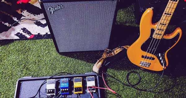 Guitar pedals, a guitar amp, and an electric guitar.