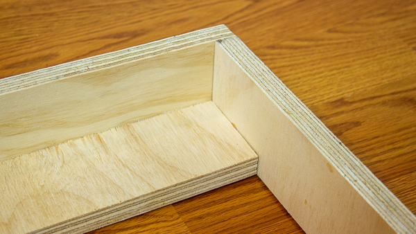 A close up front view of a support strip added to an acoustic panel frame.