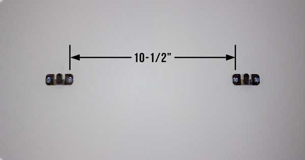 An image of two flush mount brackets screwed into drywall anchors.