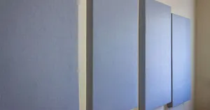 Homemade acoustic panels hanging on a wall.