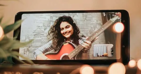 A guitarist appearing within the viewfinder of a mobile phone.
