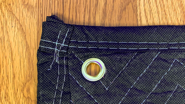 An image of a close-up view of a grommet installed into a moving blanket.