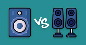 A single speaker sitting next to a pair of speakers.