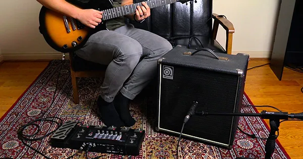 An image of a microphone positioned in front of a guitar amplifier.