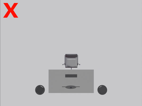 A picture of a desk incorrectly placed facing the long wall of a small studio.